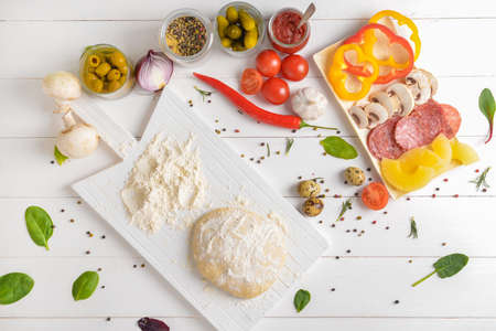 Ingredients for tasty pizza on white wooden backgroundの写真素材