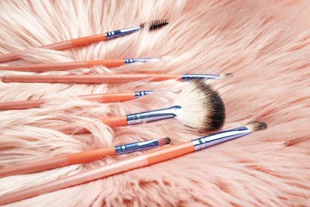 Set of makeup brushes on fluffy background
