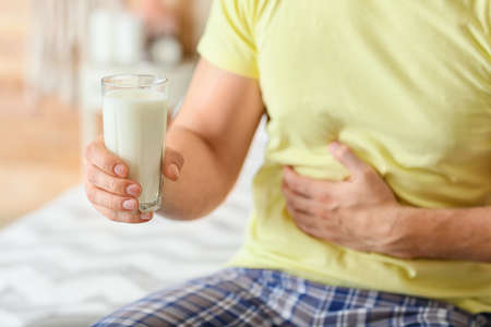 Young man with milk allergy in bedroomの写真素材