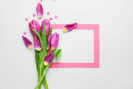 Bouquet of beautiful flowers and blank frame on white backgroundの写真素材