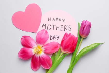 Beautiful flowers and card for Mother's Day on white background