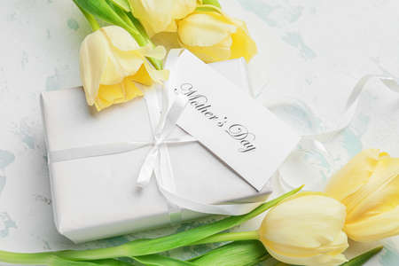 Beautiful flowers and gift for Mother's Day on light backgroundの写真素材