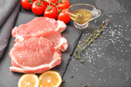 Raw pork meat with spices on dark backgroundの写真素材