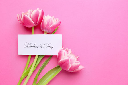 Beautiful flowers and card for Mother's Day on color backgroundの写真素材