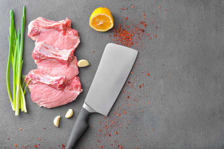 Raw pork meat with knife on dark backgroundの写真素材