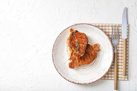 Plate with cooked pork steaks on white backgroundの写真素材