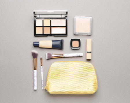 Bag with makeup brushes and decorative cosmetics on gray backgroundの写真素材
