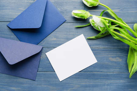 Composition with empty greeting card and envelopes on color wooden backgroundの写真素材