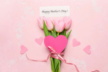 Beautiful flowers and card for Mother's Day on color backgroundの写真素材