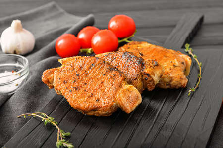 Tasty cooked pork steaks on tableの写真素材