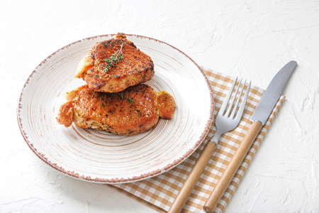 Plate with cooked pork steaks on white backgroundの写真素材