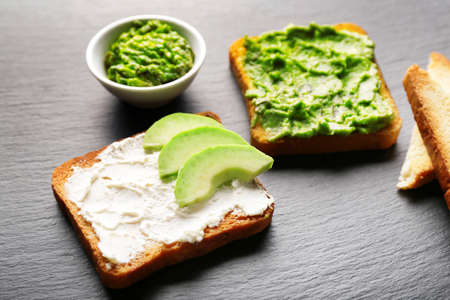 Tasty avocado sandwiches on dark backgroundの写真素材