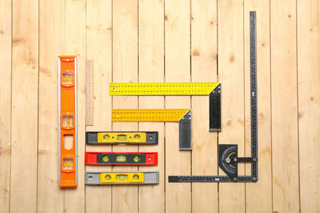 Builder's rulers on wooden background