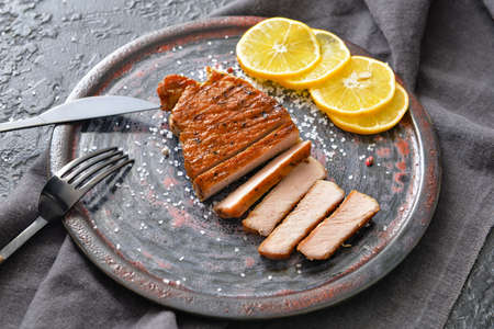 Plate with cooked pork steak on dark backgroundの写真素材