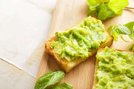 Board with tasty avocado sandwiches on tableの写真素材