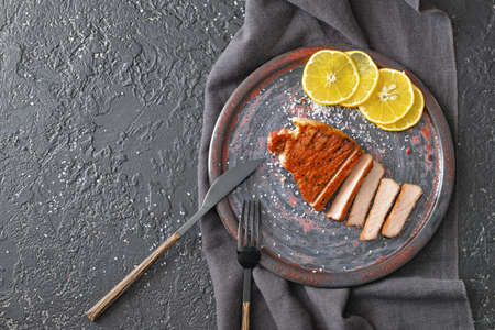 Plate with cooked pork steak on dark backgroundの写真素材