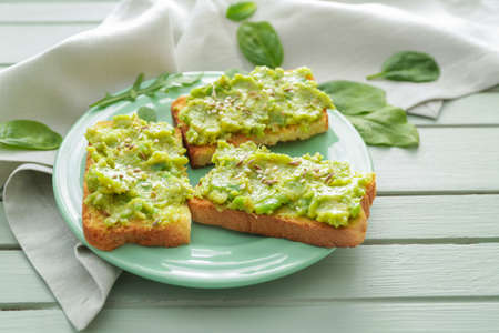 Plate with tasty avocado sandwiches on tableの写真素材