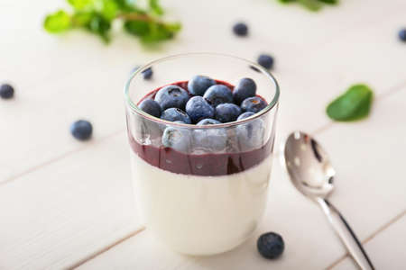 Glass with tasty panna cotta on white wooden backgroundの写真素材