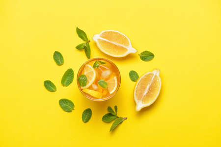 Glass of tasty cold ice tea on color backgroundの写真素材