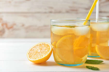 Glasses of tasty cold ice tea on white wooden backgroundの写真素材