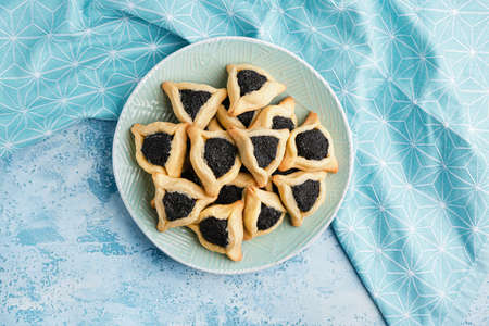 Plate with tasty hamantaschen for Purim holiday on color backgroundの写真素材