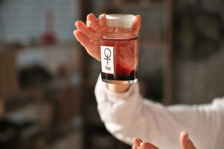 Female alchemist with potion in laboratoryの写真素材