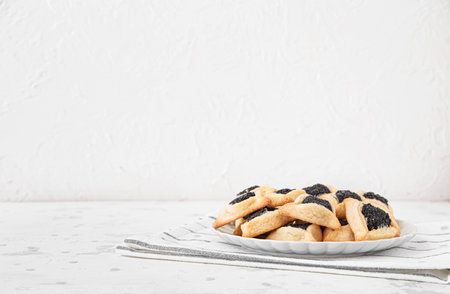Plate with tasty hamantaschen for Purim holiday on white backgroundの写真素材