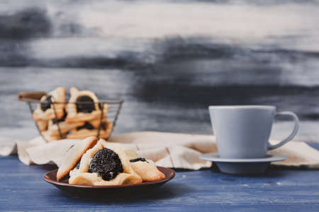 Plate with tasty hamantaschen for Purim holiday on tableの写真素材