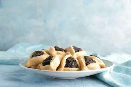 Plate with tasty hamantaschen for Purim holiday on color backgroundの写真素材