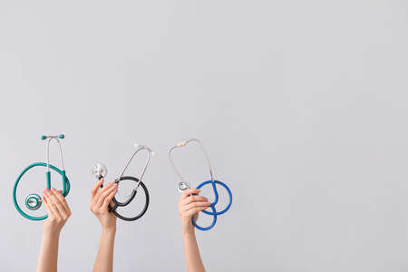Hands with stethoscopes on gray backgroundの写真素材