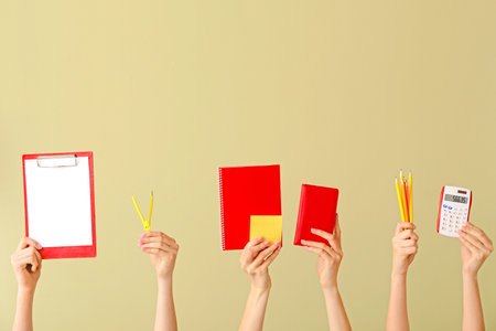 Many hands with school supplies on color backgroundの写真素材