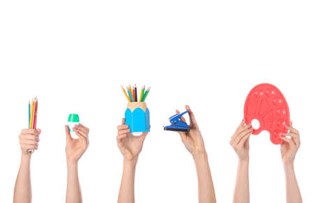Many hands with school supplies on white background