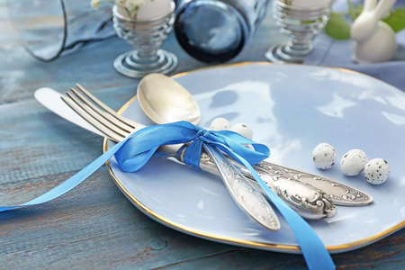 Beautiful Easter table setting on color wooden backgroundの写真素材