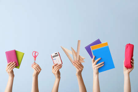 Many hands with school supplies on color backgroundの写真素材