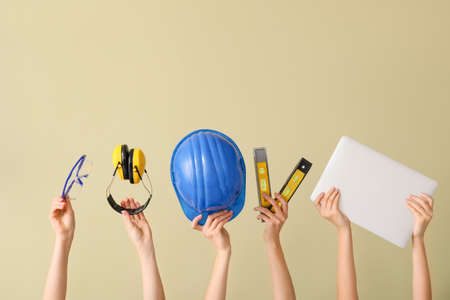 Many hands with architect's supplies and laptop on color backgroundの写真素材