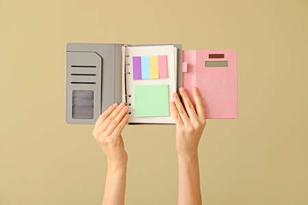 Hands with notebook on color backgroundの写真素材