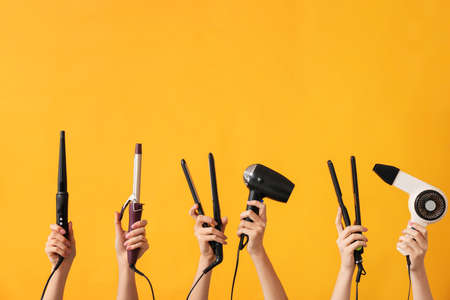 Many hands with hairdresser's devices on color backgroundの写真素材