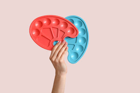 Hand with paint palettes on light backgroundの写真素材