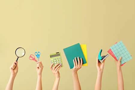 Many hands with school supplies on color backgroundの写真素材