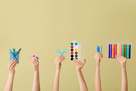 Many hands with school supplies on color backgroundの写真素材