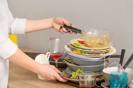 Woman with dirty dishes in kitchenの写真素材
