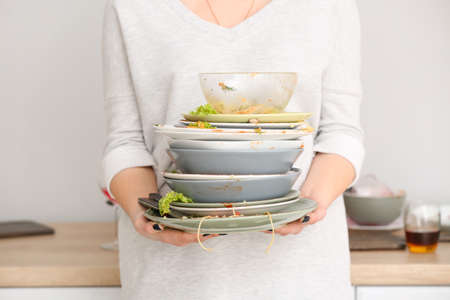 Woman with dirty dishes in kitchenの写真素材
