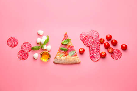 Tasty pizza with ingredients on color backgroundの写真素材