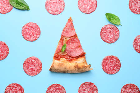 Slice of tasty pizza with sausages on color backgroundの写真素材