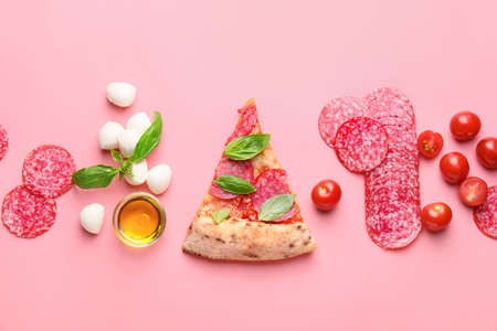 Tasty pizza with ingredients on color backgroundの写真素材