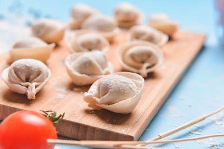 Raw fresh dumplings on wooden boardの写真素材