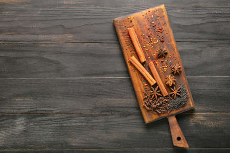Board with different spices on dark wooden backgroundの写真素材