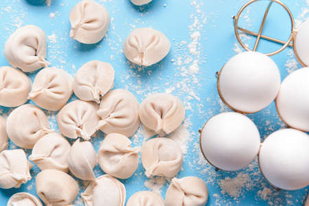 Raw fresh dumplings with eggs on color backgroundの写真素材