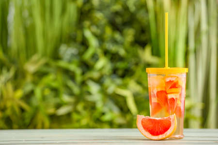 Glass with cold tea on table outdoorsの写真素材