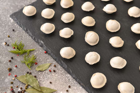 Raw fresh dumplings on slate plateの写真素材